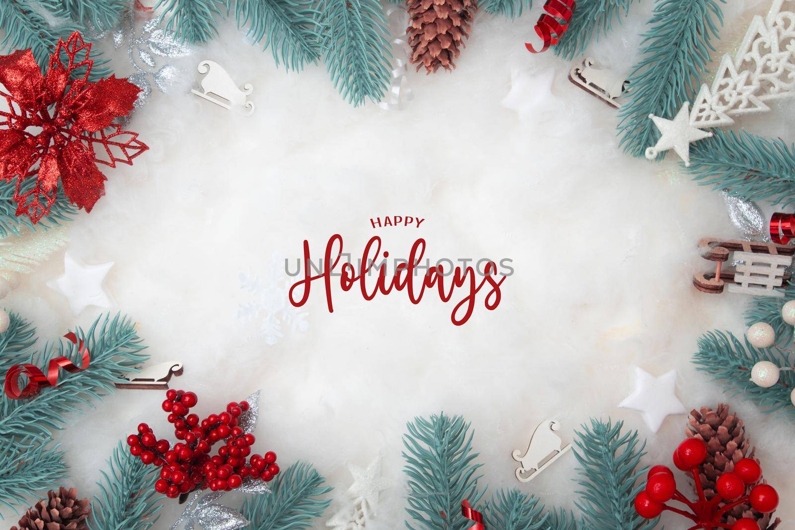 Happy Holidays text with frame made of Christmas decorations flat lay on a snowy background with copy space