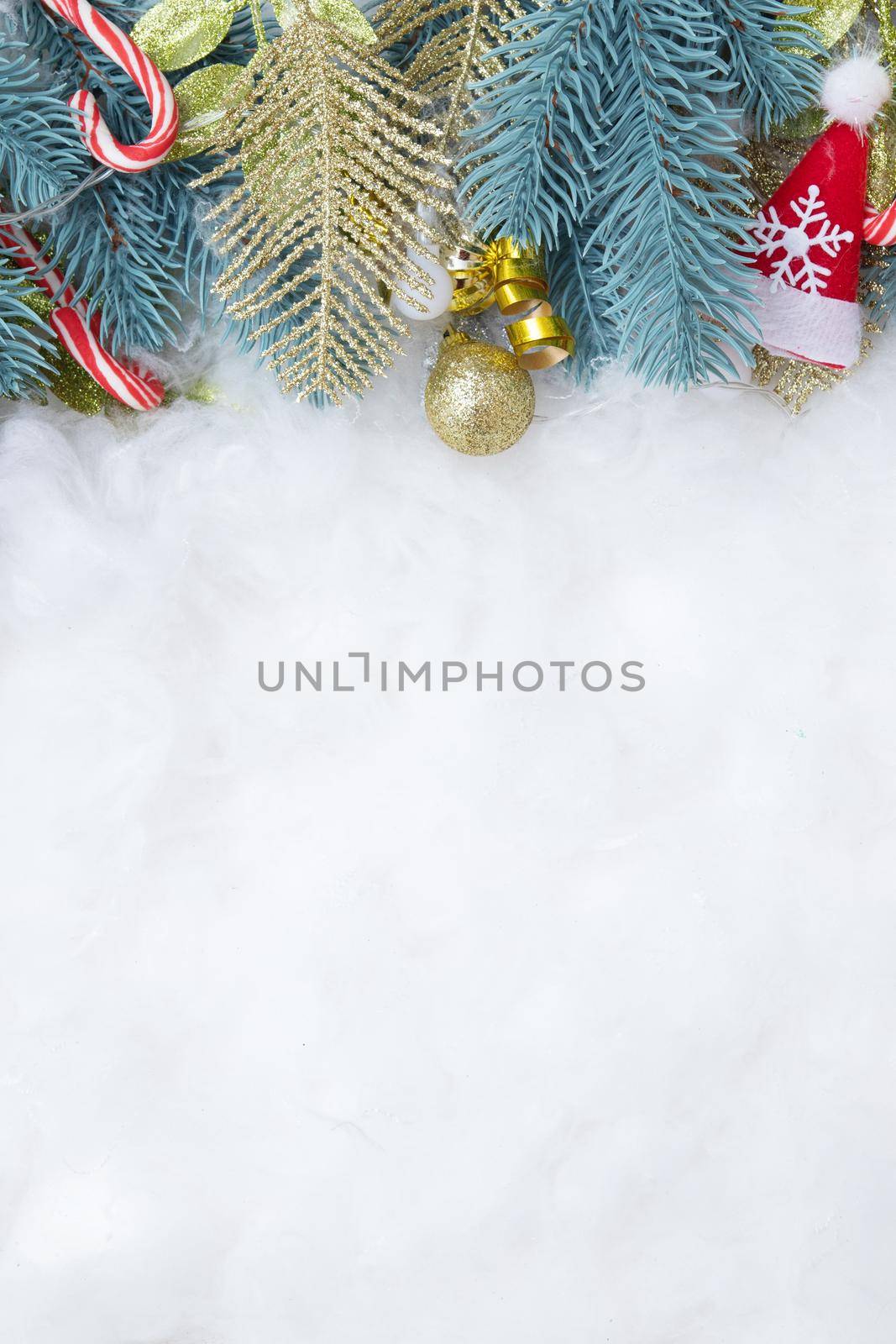 Frame made of fir branch and Christmas decorations flat lay on a snowy background with copy space vertical format
