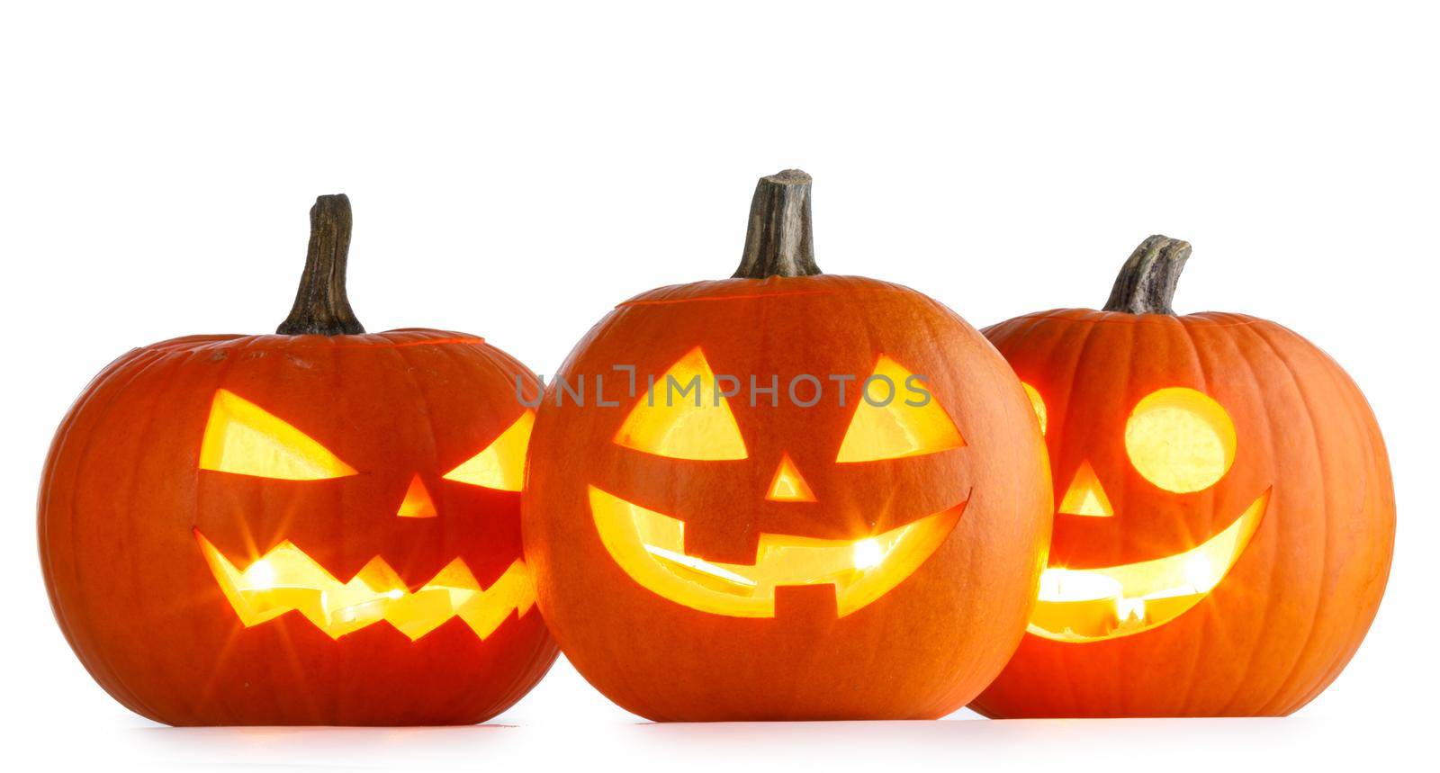 Three Halloween glowing lantern pumpkins in a row isolated on white background