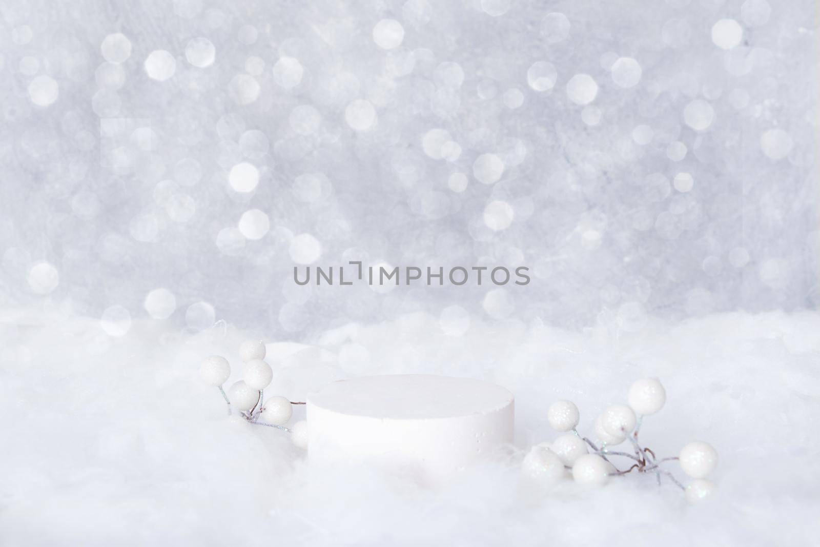 Podium mock-up for cosmetics in the snow with decorative berries on a bokeh background. Cristmas presentation of your products.