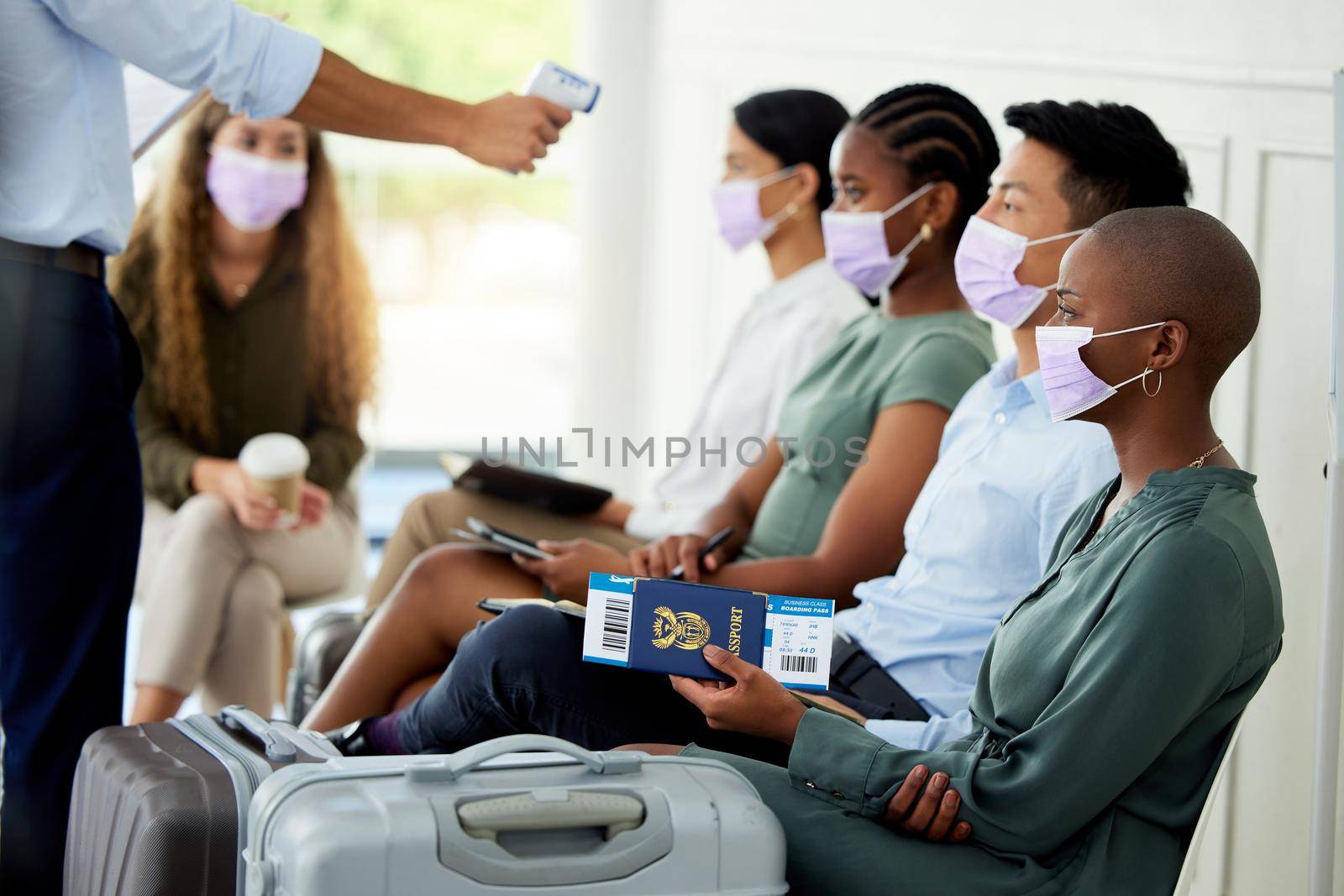 Covid, travel and airport with security scanning a woman with an infrared thermometer for temperature. Immigration, restrictions and passport with a female passenger getting ready to board a flight.