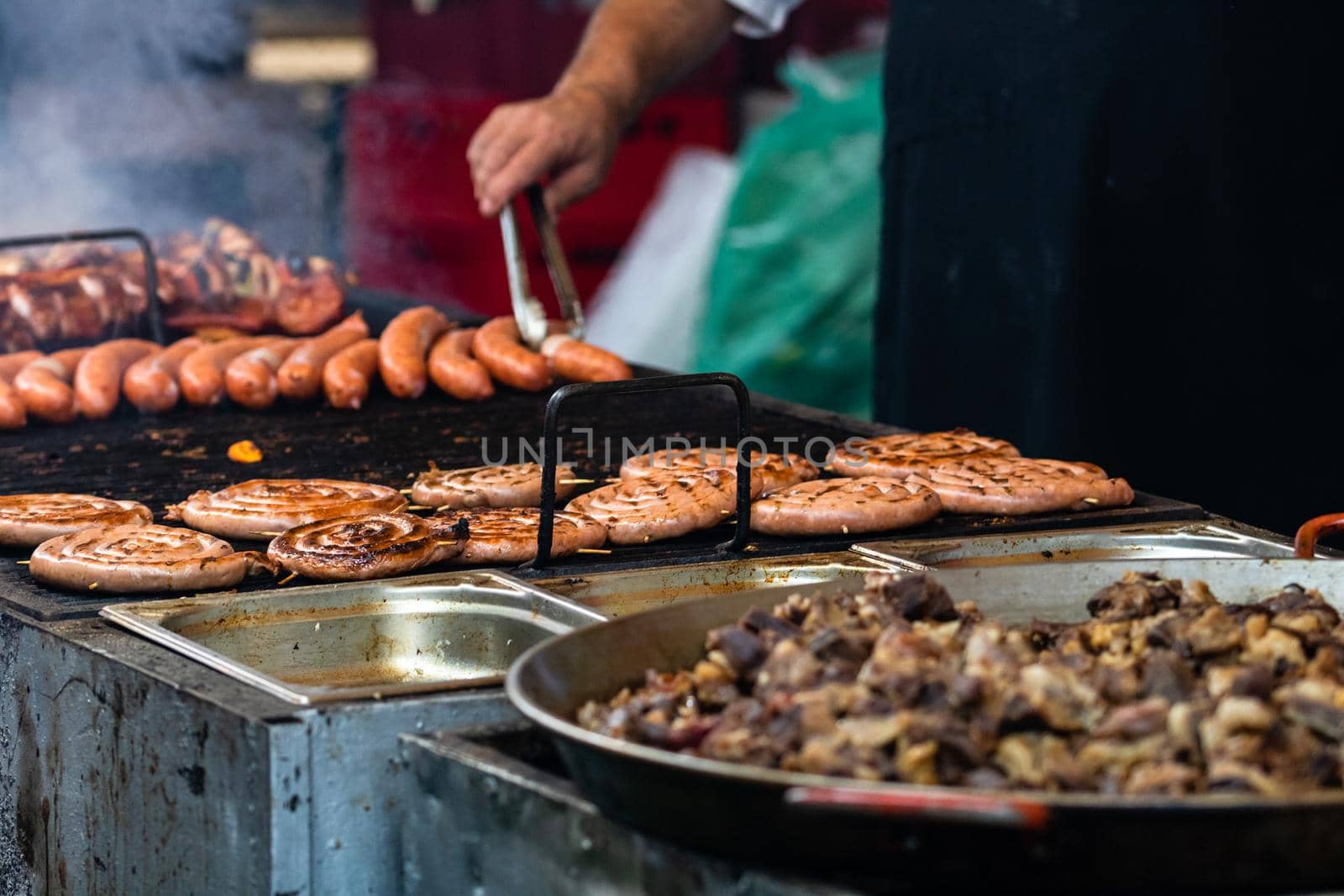 Grilling tasty food on barbecue. Steak, sausages on grill at food festival by vladispas