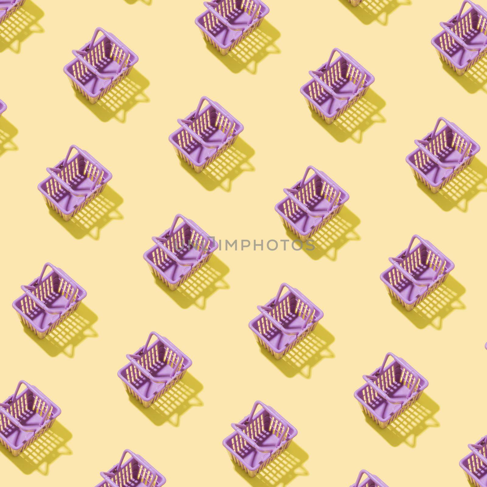 Pattern with miniature shopping basket in a supermarket on a yellow background. Minimalistic creative shopping concept