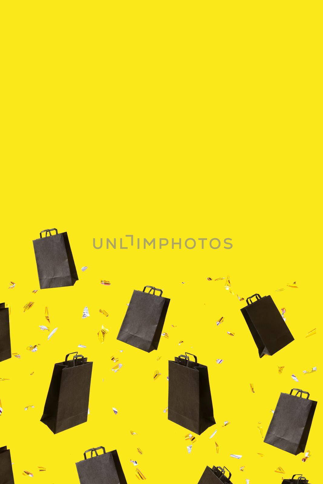 Pattern with black sale shopping bags are flying and sparkles on yellow background with copy space. Black Friday creative concept