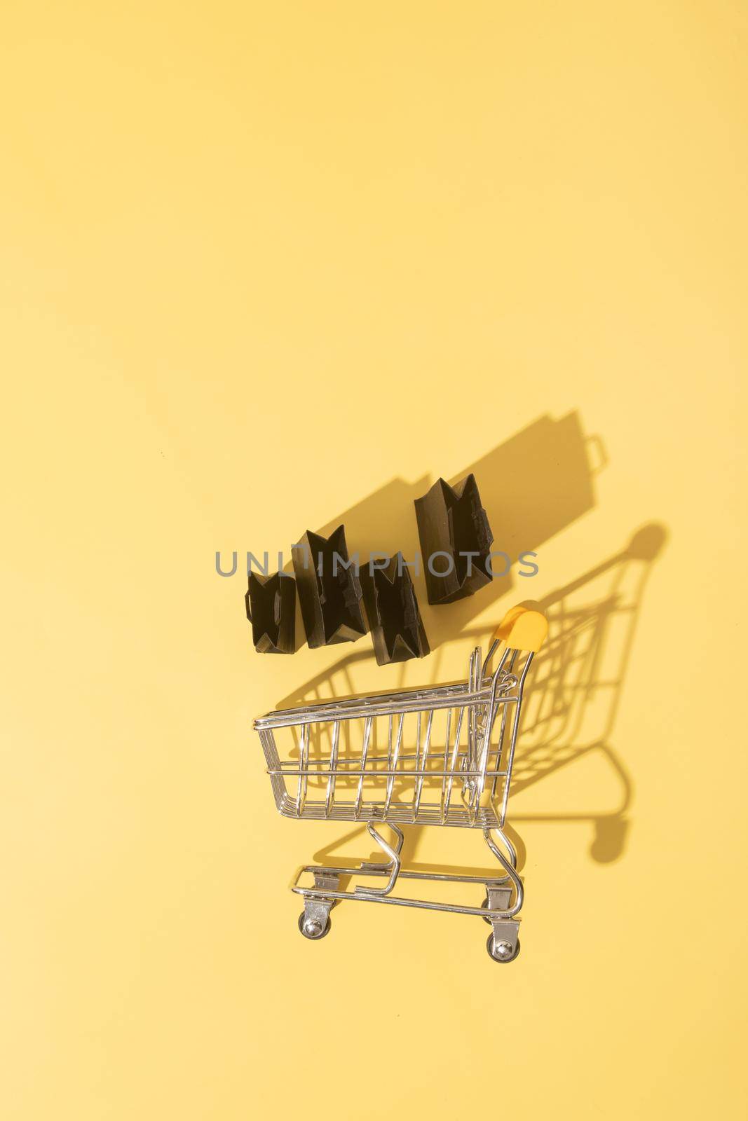 Flat lay miniature supermarket cart with shopping bags in black friday sale