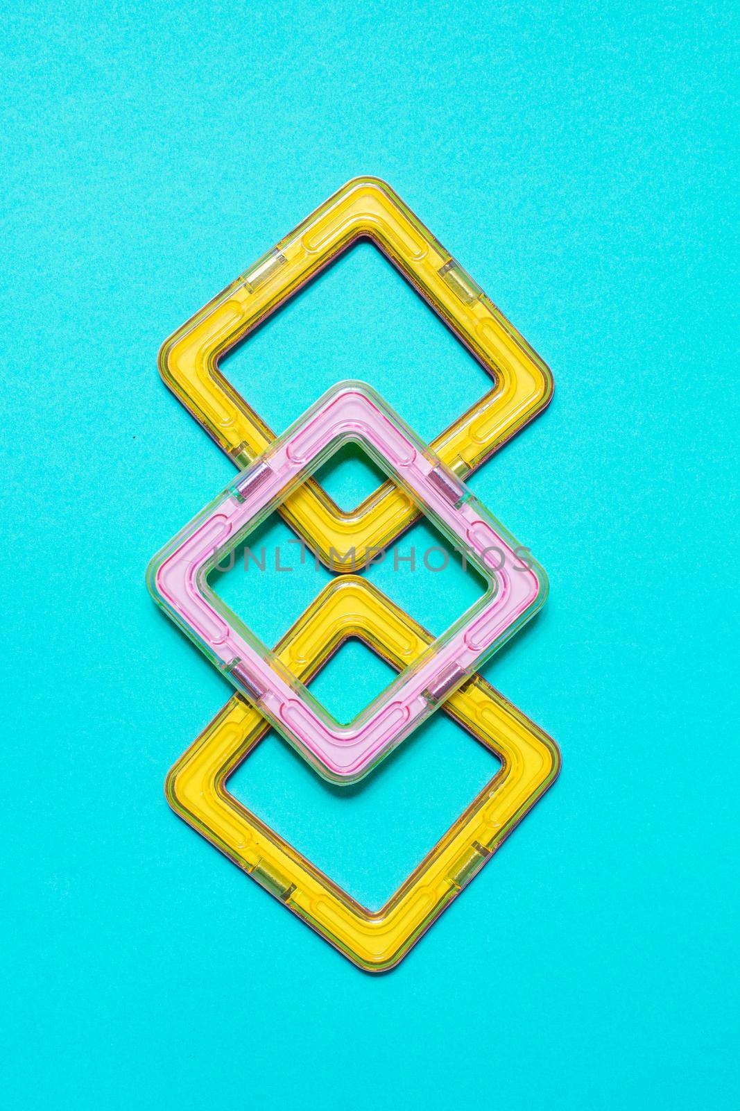 Constructor children plastic yellow colored on a pastel blue by Ciorba