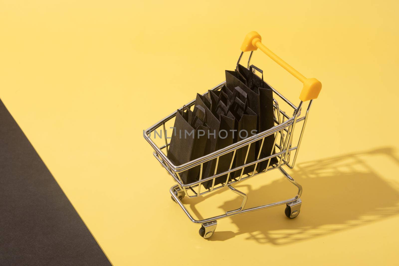 Miniature supermarket cart with shopping bags in black friday sale