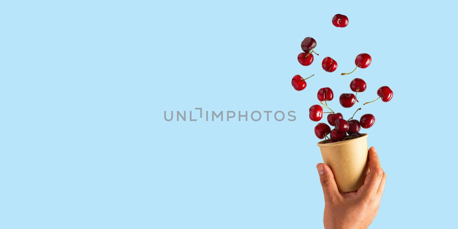Flying cherries vertical isolated as package design elements. Fresh raw cheery falling in the air by PhotoTime