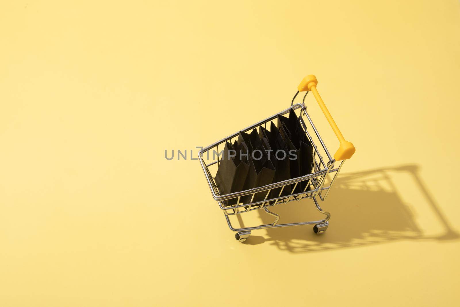 Miniature supermarket cart with shopping bags in black friday sale