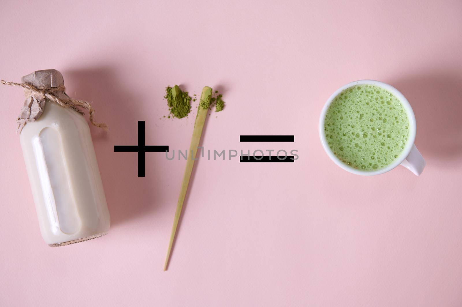 A bottle of organic plant-based milk plus scoop of powdered green tea equal Japanese matcha latte, over pink background. by artgf