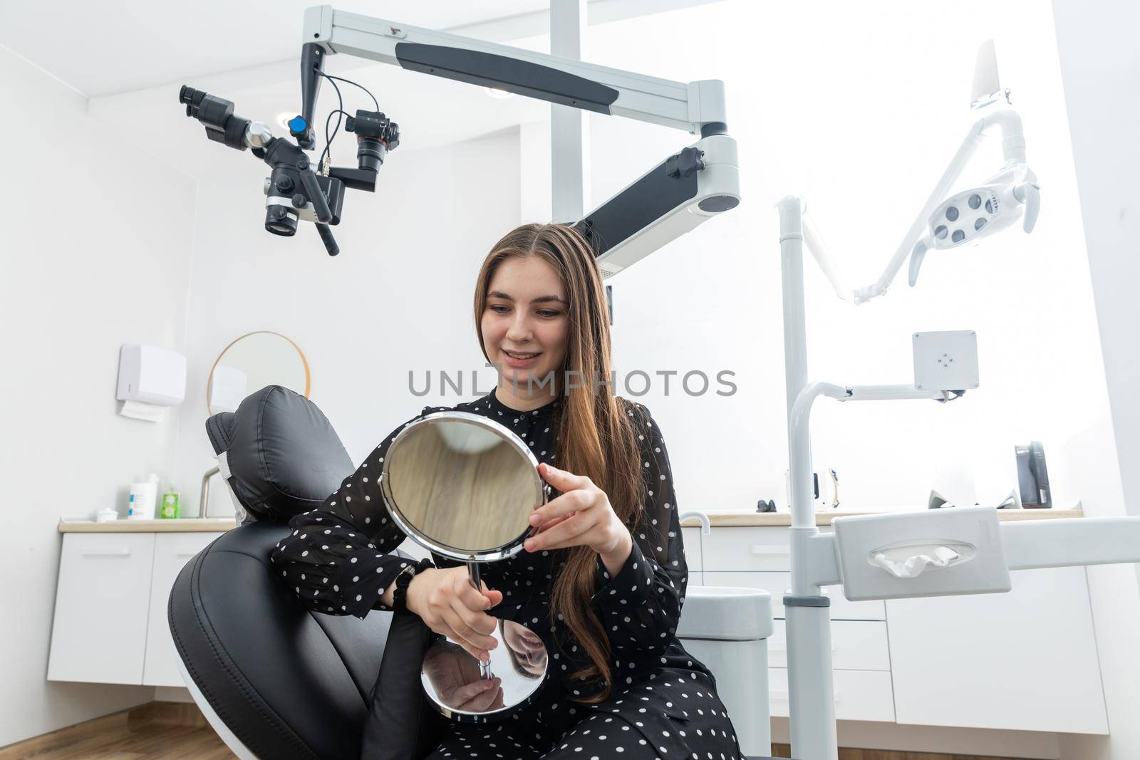 Young woman looking in a mirror after a dental procedure