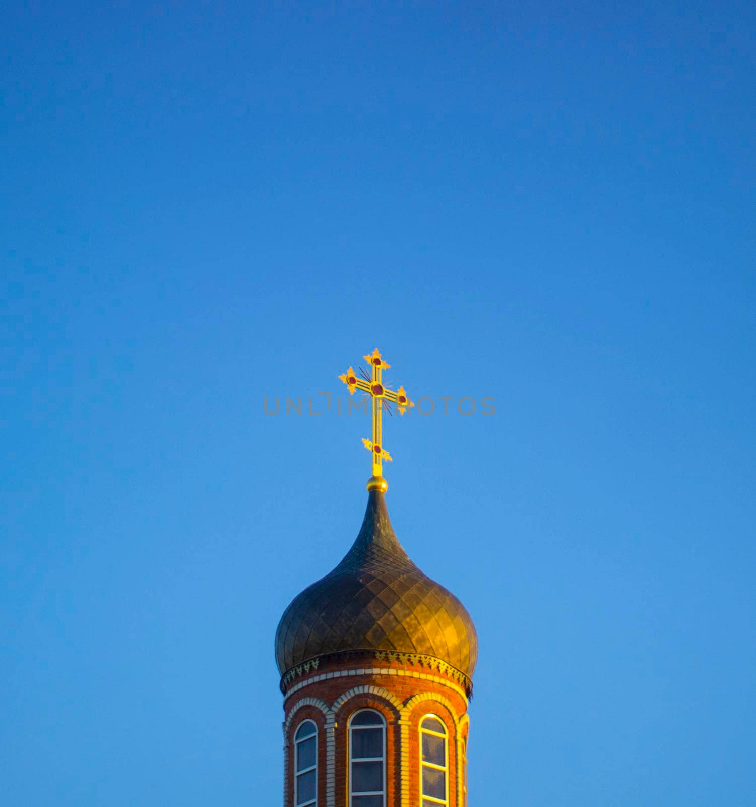 Dome of Orthodox church on blue sky background. Kirk shining of Sun.
