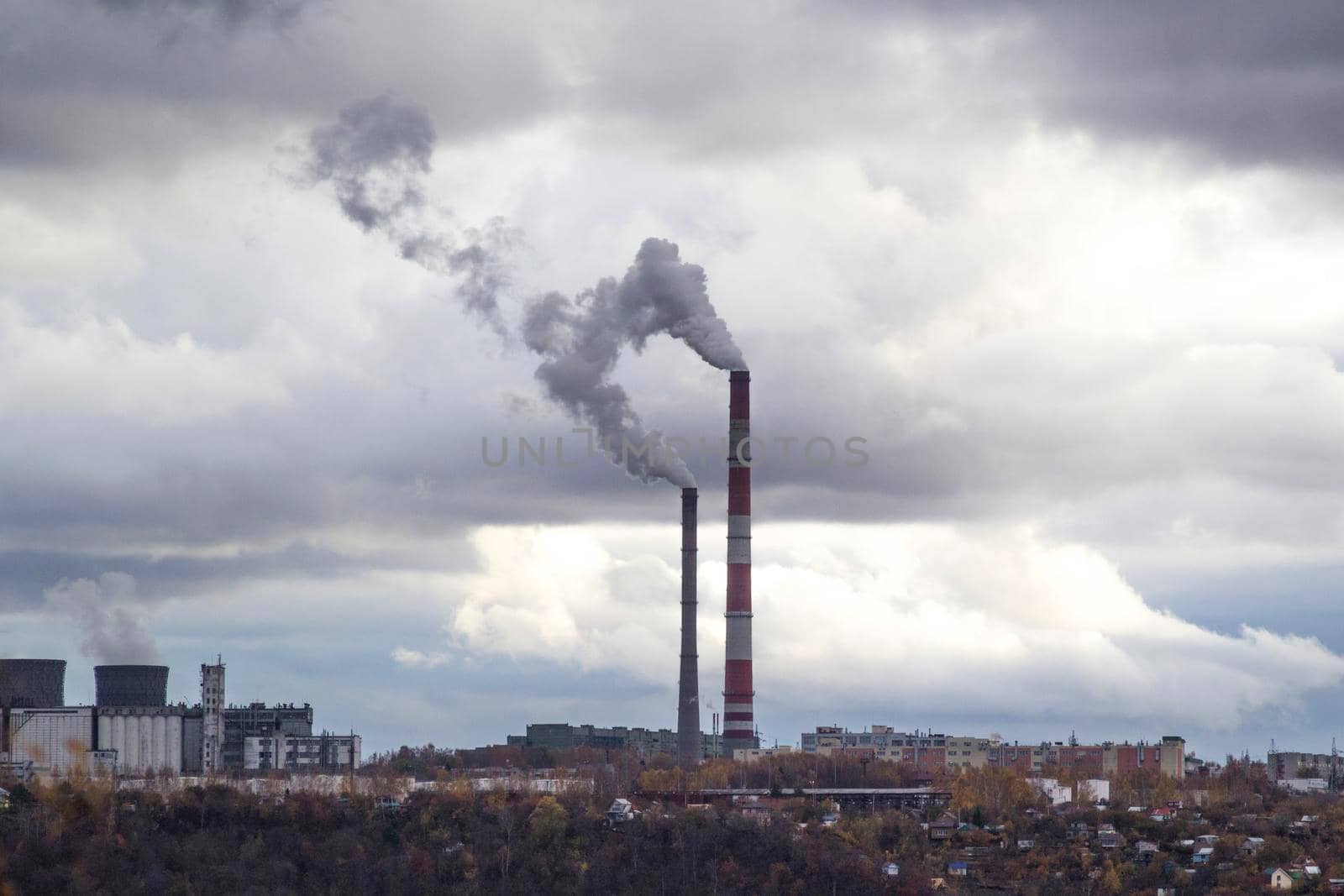 Urban cloudy landscape. Citypipes fuming an industrial area illustrating pollution and production harm.