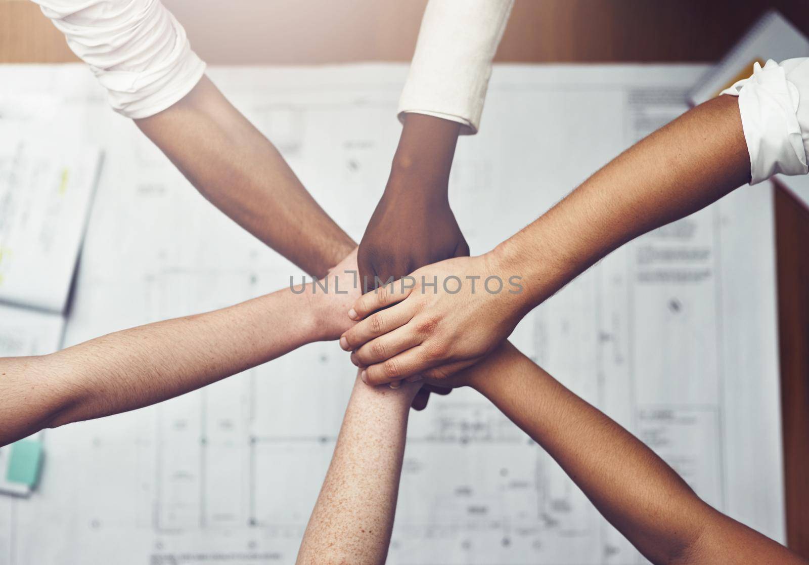 We all work together in perfect harmony. unrecognizable businesspeople joining their hands together in unity