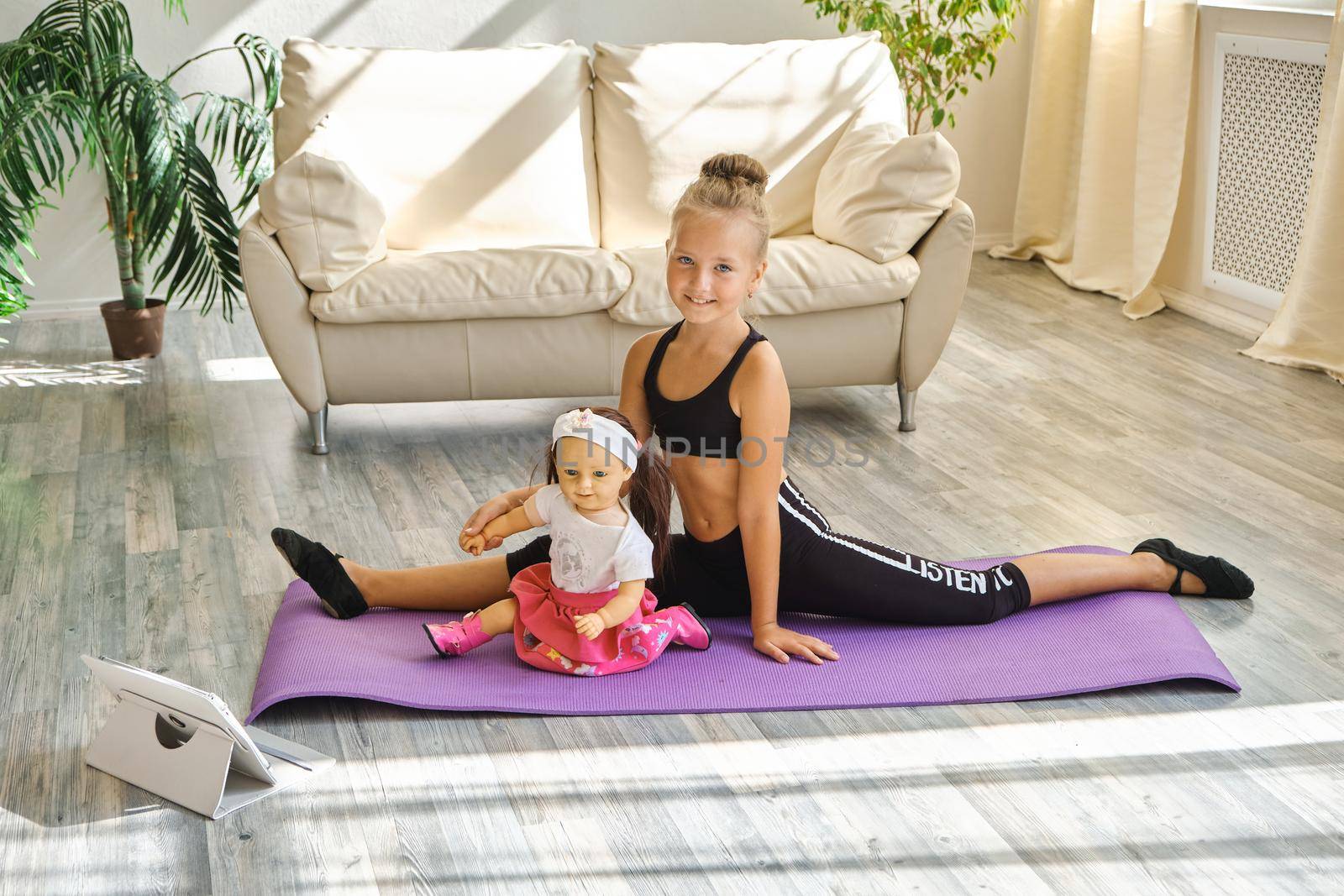 Kid repeating exercises while watching online yoga gymnastics session by InnaVlasova