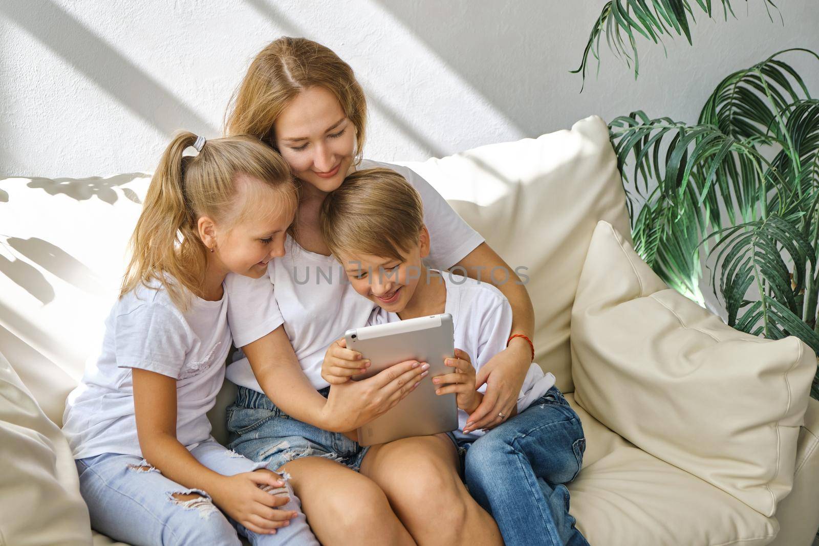 Young mother with kids daughter and boy using digital tablet computer device by InnaVlasova