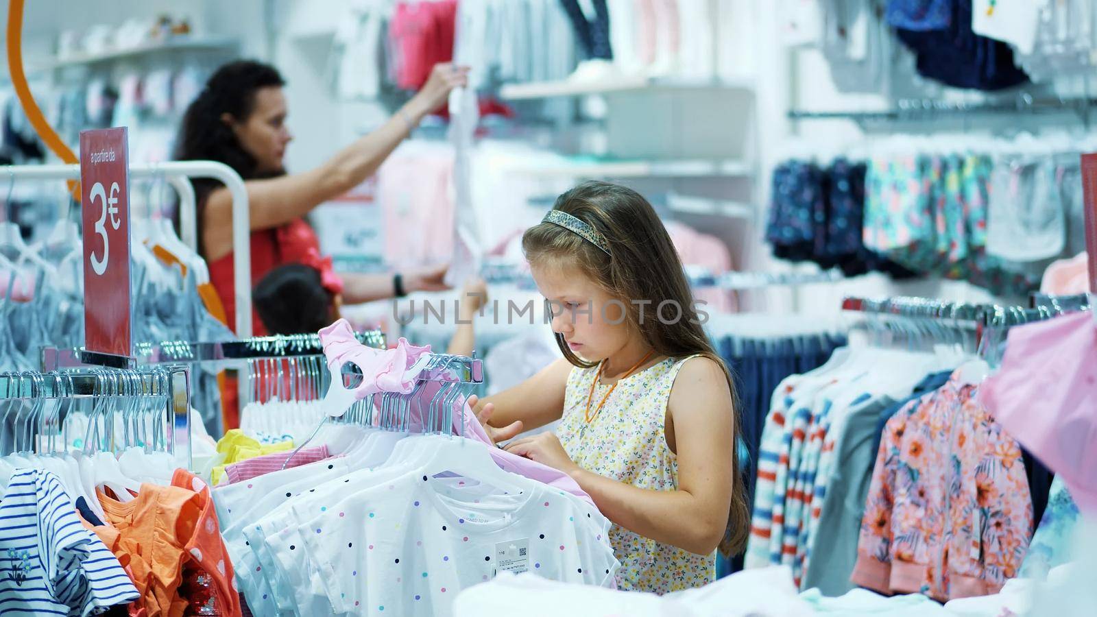 shopping in the store. children's clothing department. girl, kid, chooses things in the store. Little fashion-girl. little shopaholic. tedious shopping in stores, shops by djtreneryay