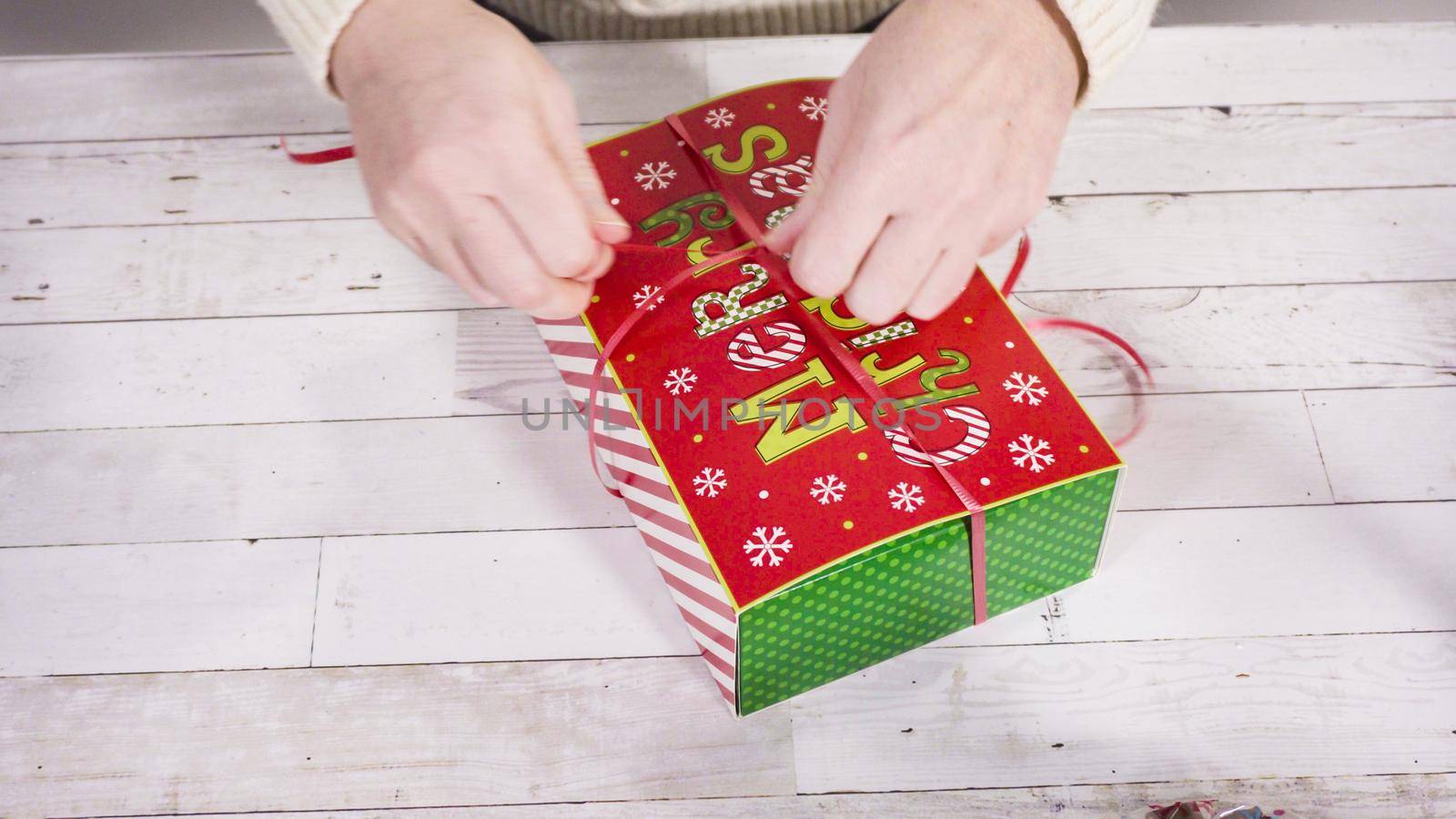 Step by step. Packaging homemade fudge and cookies into a Christmas gift box.