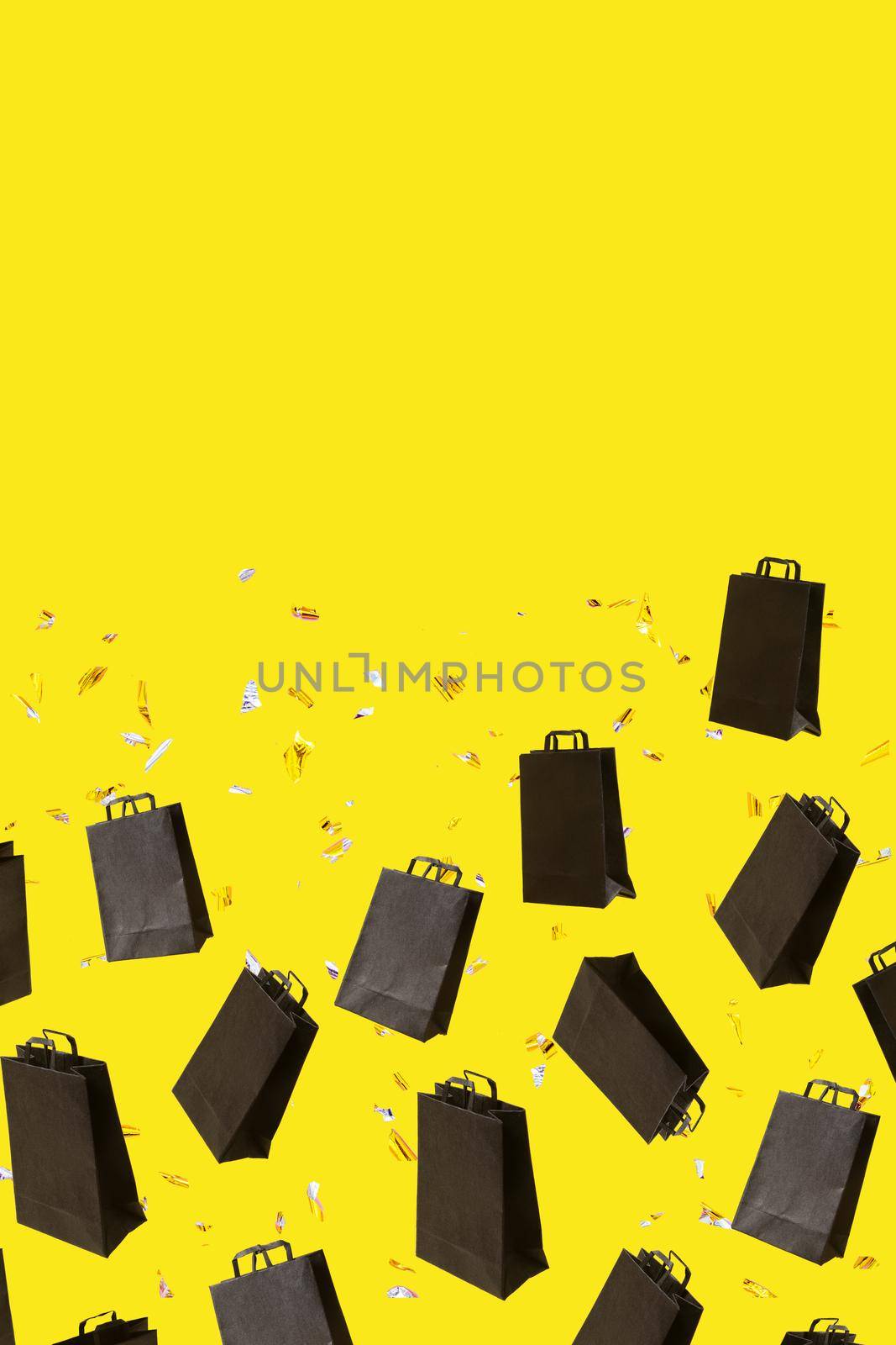 Pattern with black sale shopping bags are flying and sparkles on yellow background with copy space. Black Friday creative concept
