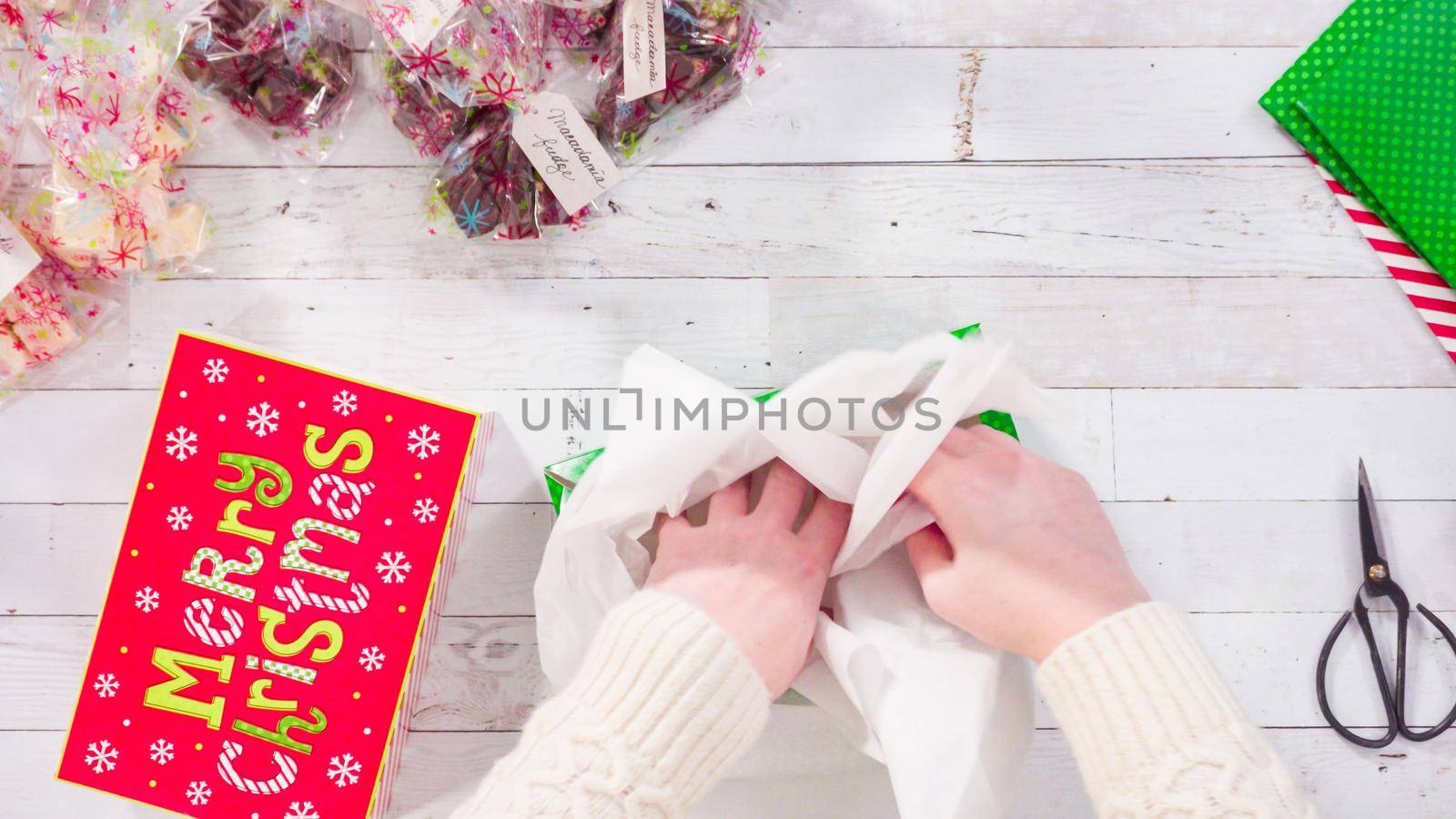 Flat lay. Step by step. Packaging homemade fudge and cookies into a Christmas gift box.