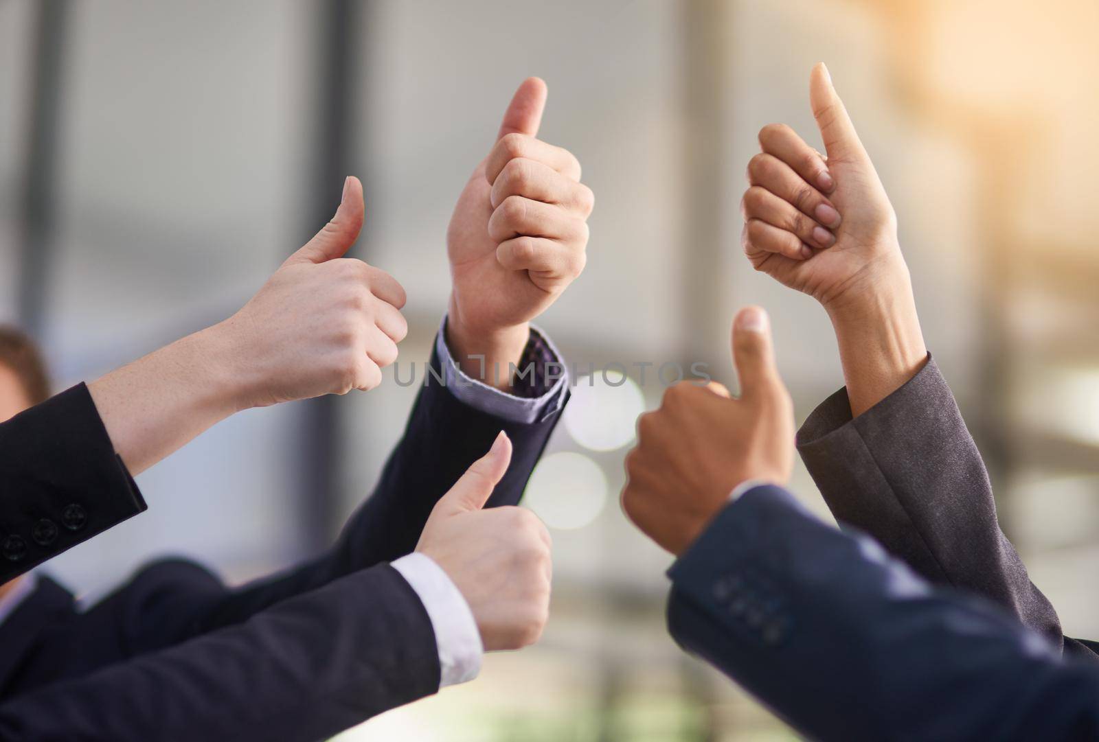 Thumbs up to your achievements. a group of office workers giving thumbs up together. by YuriArcurs