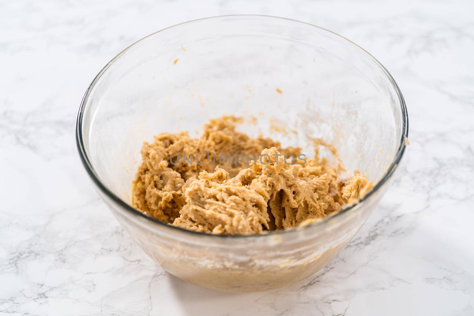 Mixing ingredients with a hand mixer to bake eggnog cookies with a chocolate gingerbread man.