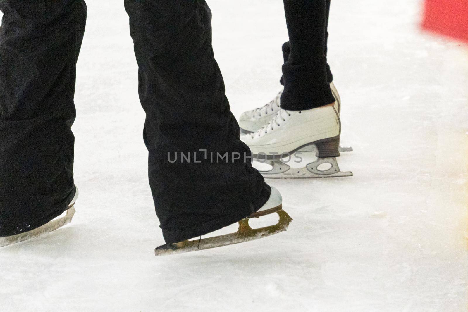 View of a figure skater and her coach feet at the figure skating practice.