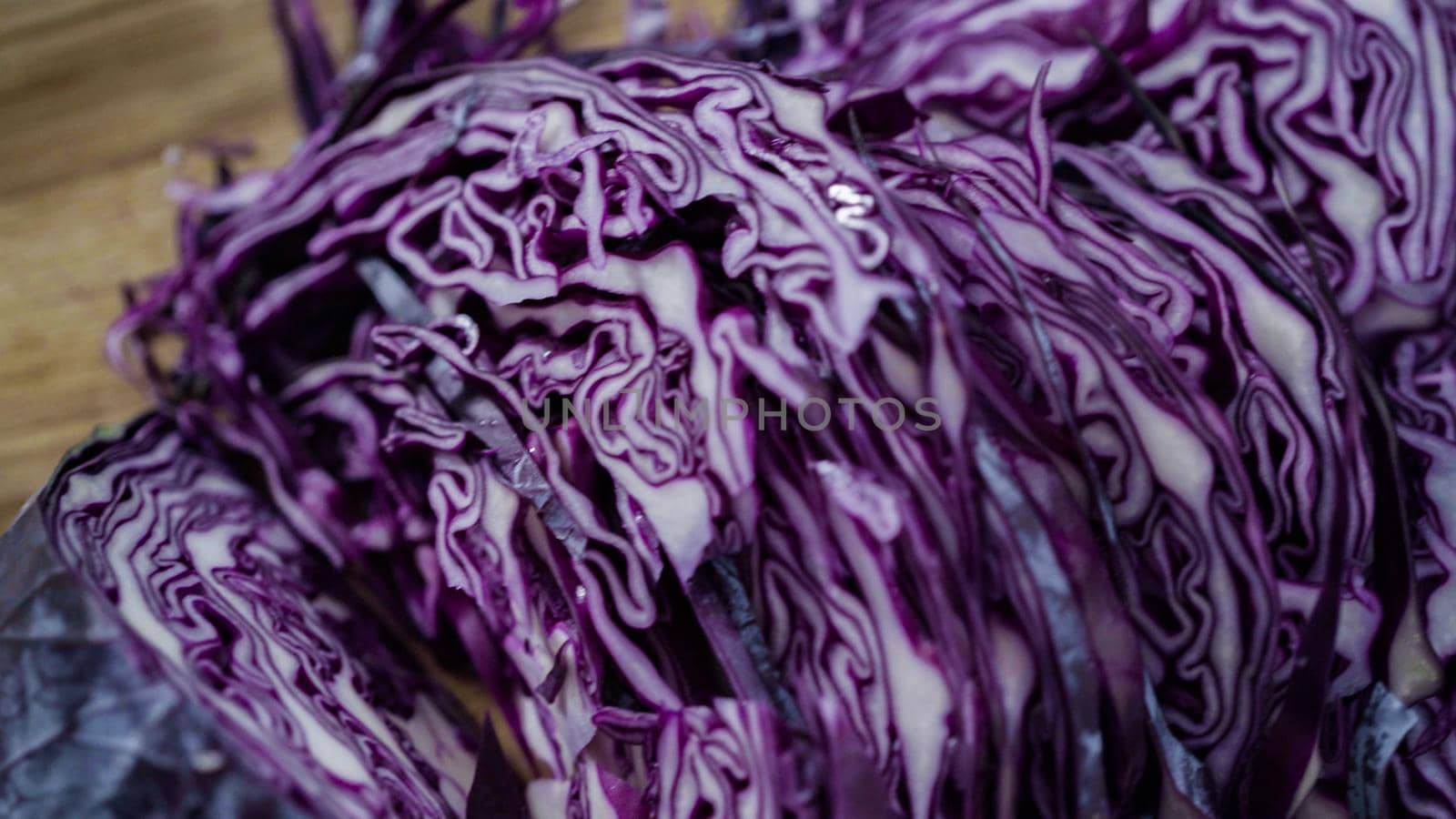 Step by step. Shredded organic cabbage on a wood cutting board.