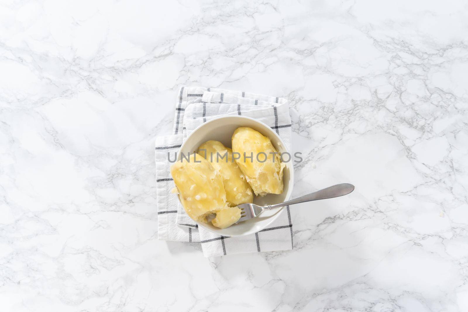 Flat lay. Mashed potatoes. Cooking whole peeled potatoes in a white bowl.