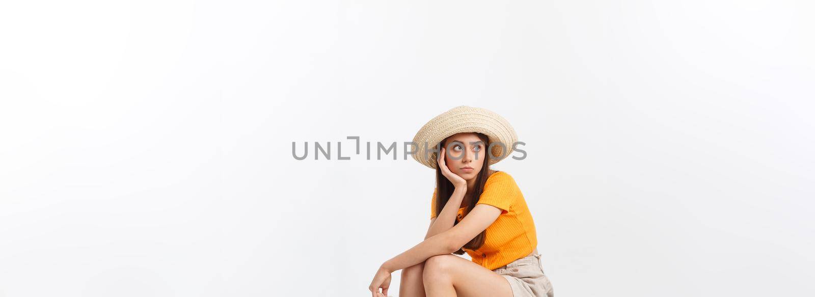 Lifestyle and travel Concept: Young beautiful caucasian woman is sitting on suitecase and waiting for her flight.Isolated over white background.