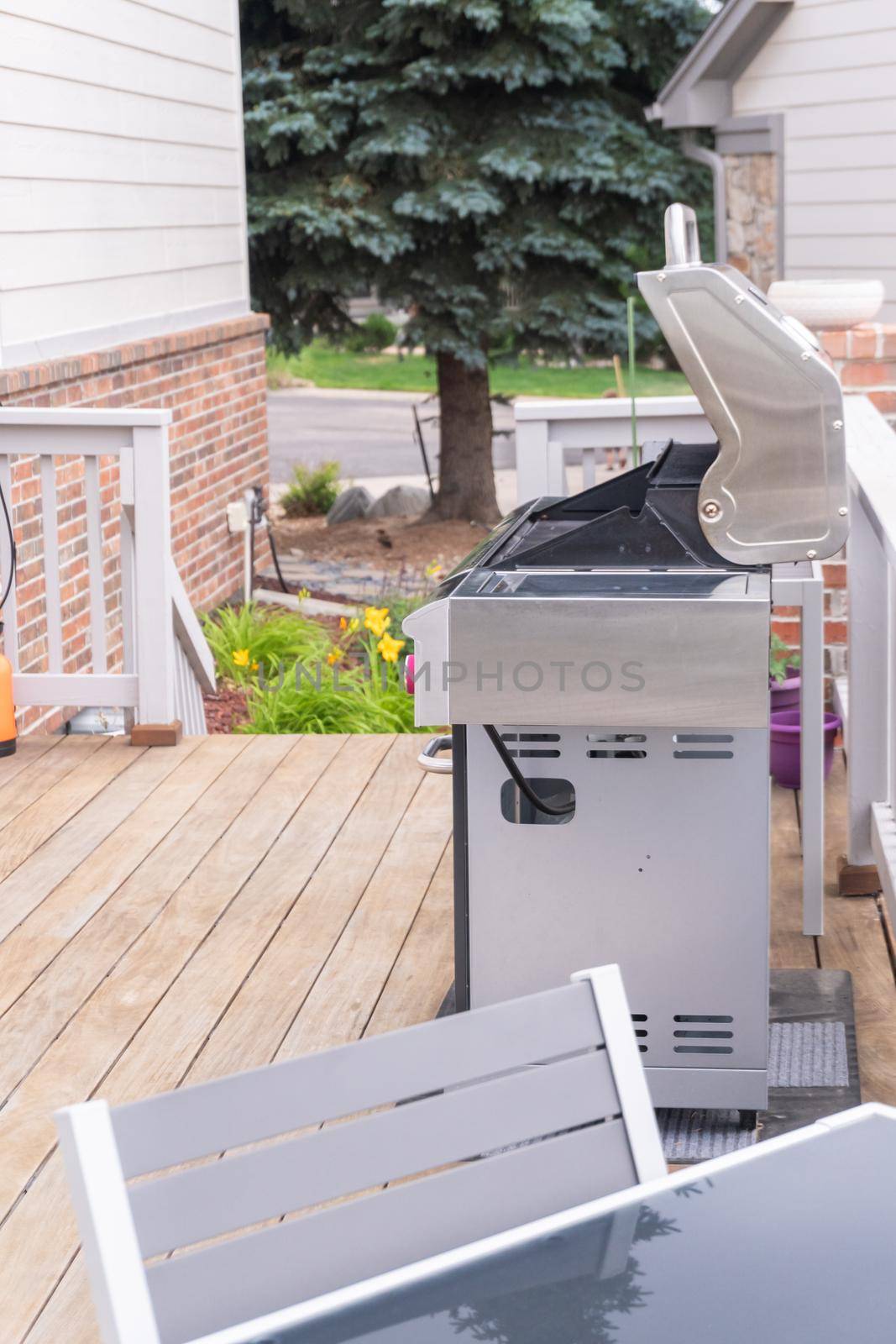 Outdoor six-burner gas grill on the back patio of a luxury single-family home.