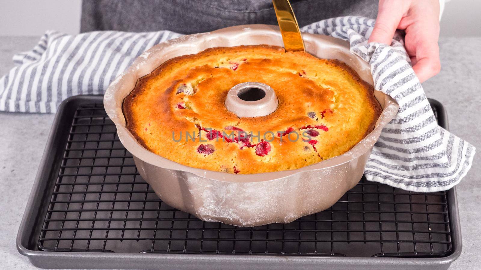 Step by step. Cooling lemon cranberry bundt cake on the kitchen wire rack.