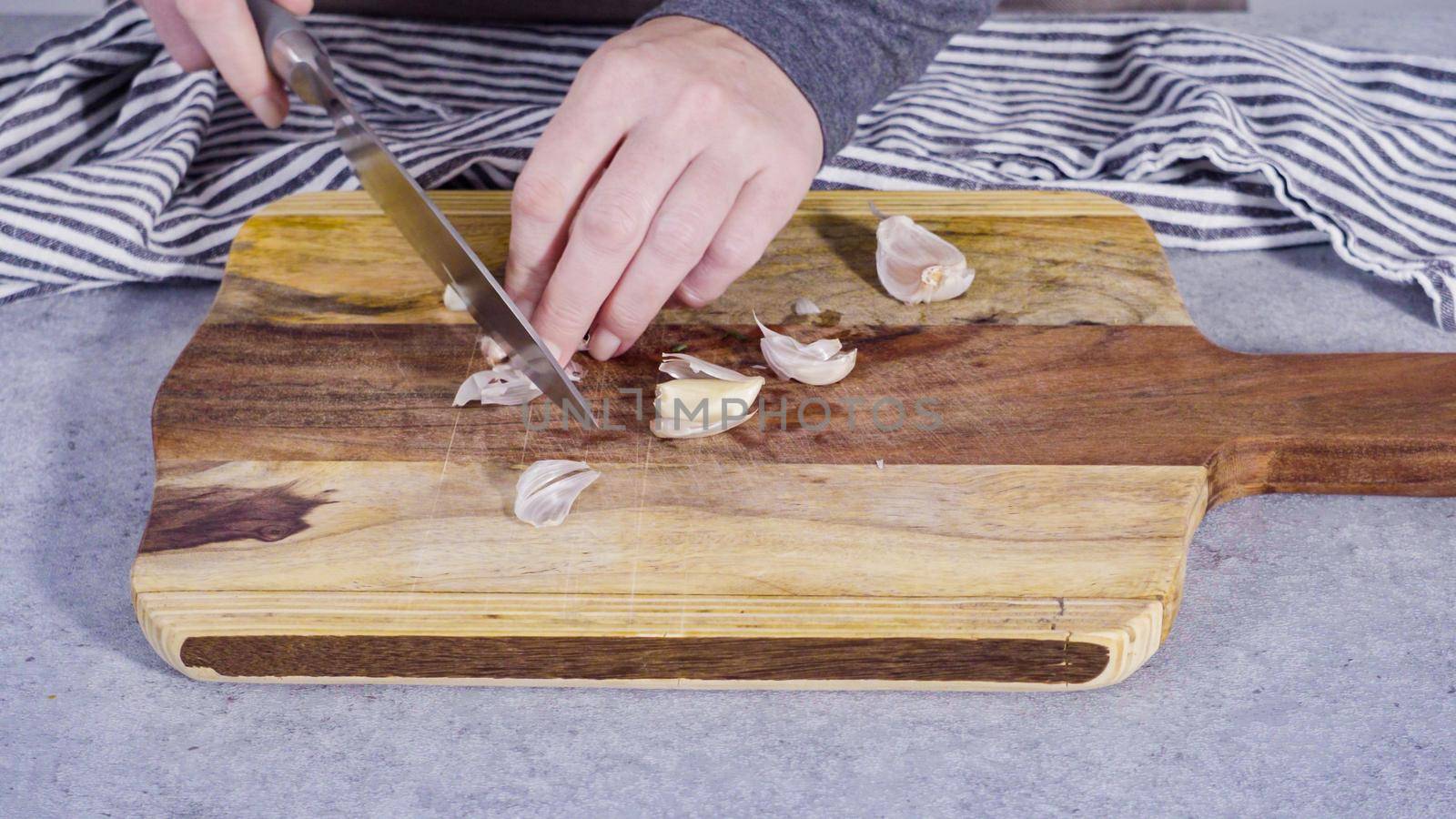 Cutting organic garlic on a wood cutting board.