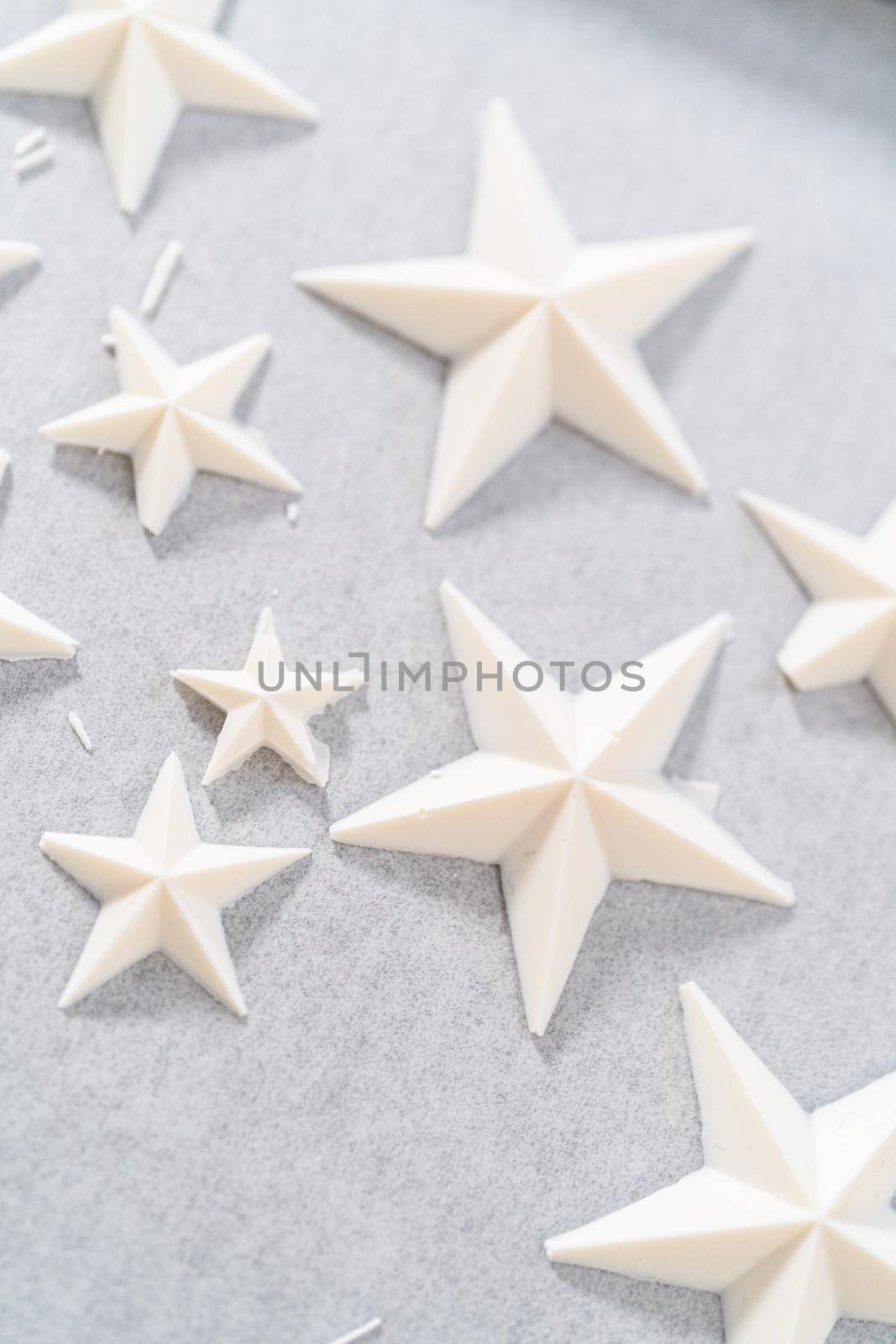 Filling silicone mold with white melted chocolate to make chocolate chocolate stars for American flag mini cupcakes.