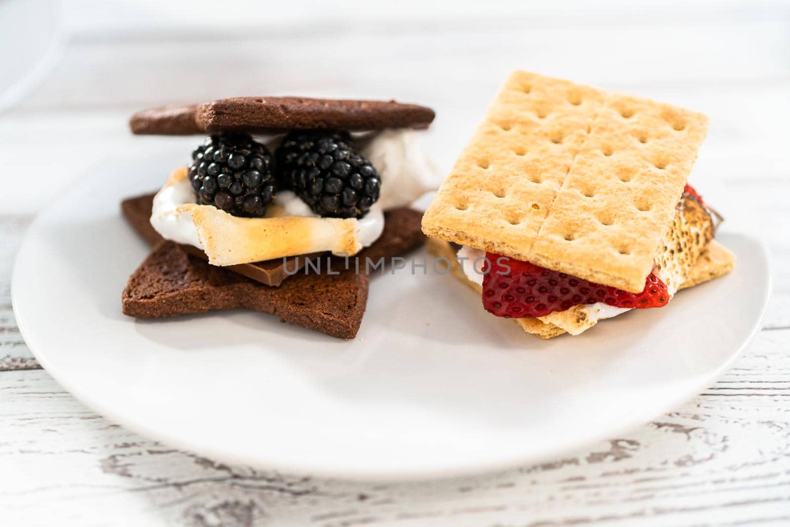 Making s'mores on a homemade star-shaped chocolate graham cracker with toasted marshmallow and fruits.