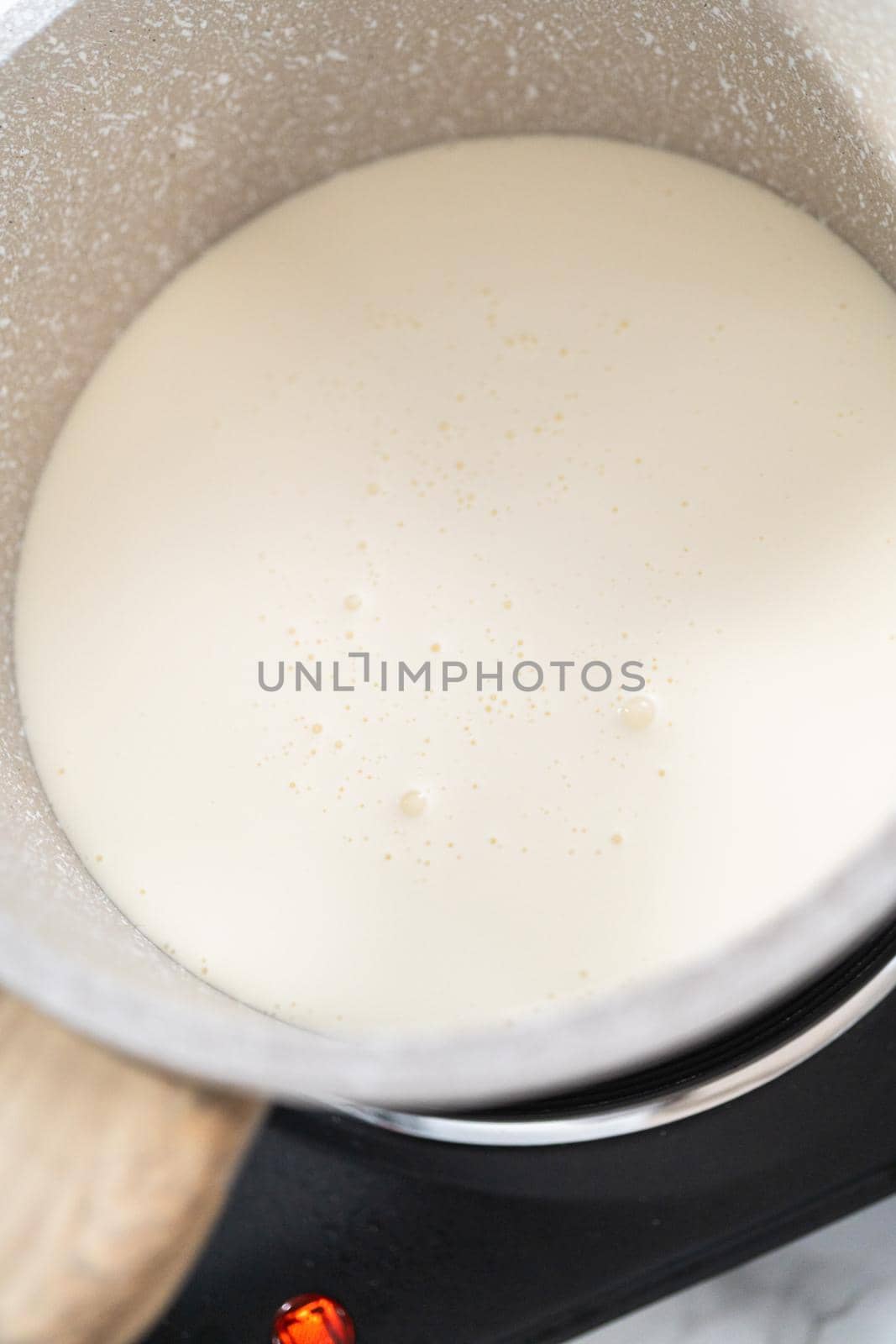 Preparing chocolate ganache in a small saucepan.