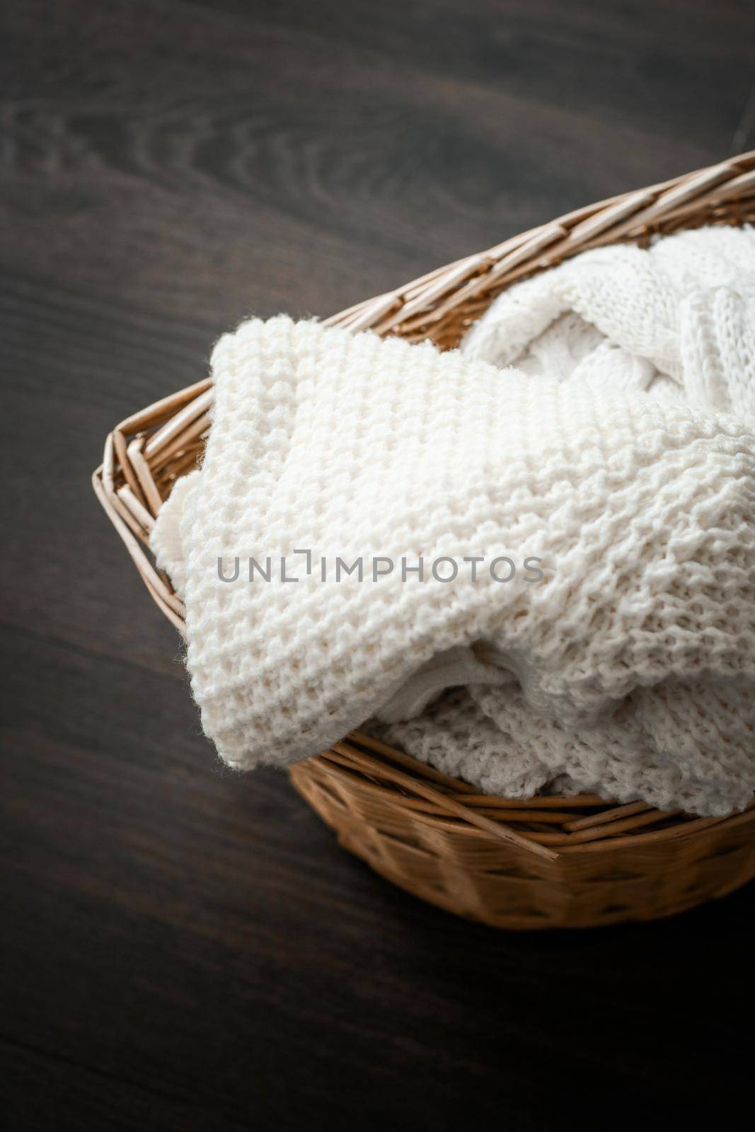 Knitwear, fabric textures and rustic lifestyle concept - Knitted winter clothes in a basket