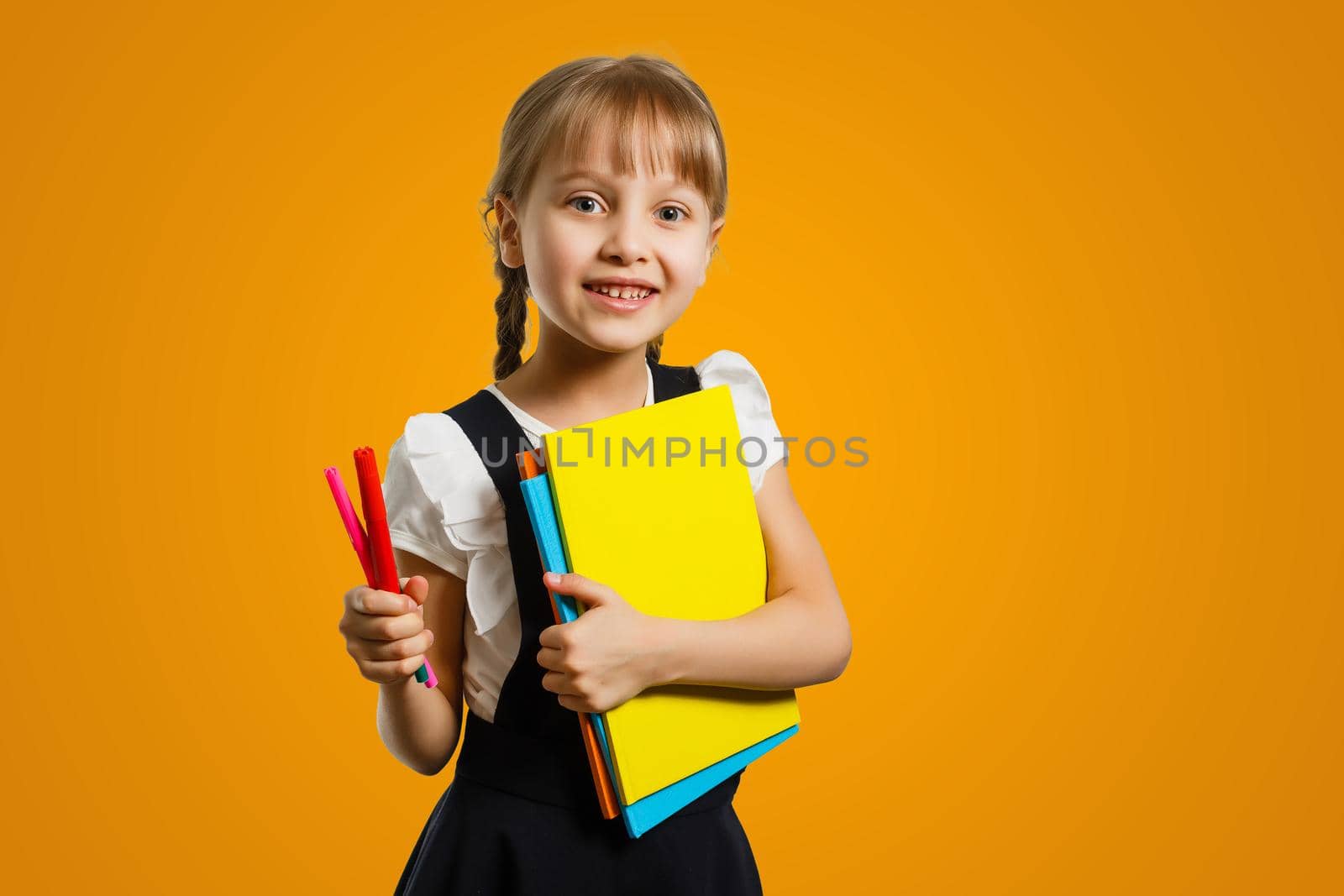 Cropped close up shot of a happy smart caucasian teenager schoolgirl pupil student wearing bag going back to school for new academic educational year isolated in yellow background