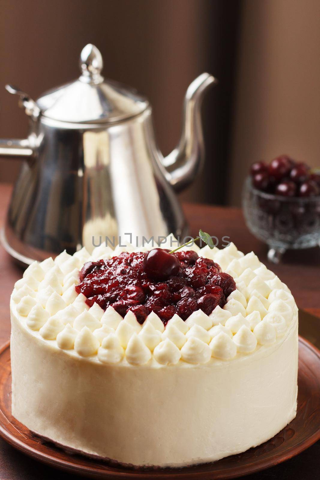 Biscuit cake, cherry souffle with cream cheese and cherry confiture on wooden background. Close-up,vertical photo