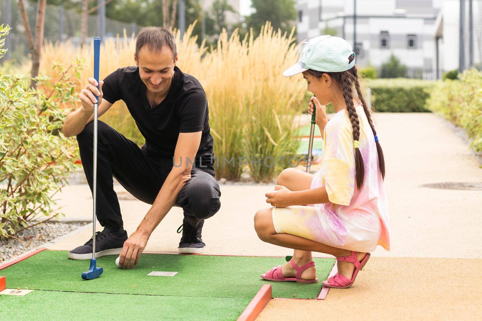 Closeup of player play mini golf with ball.