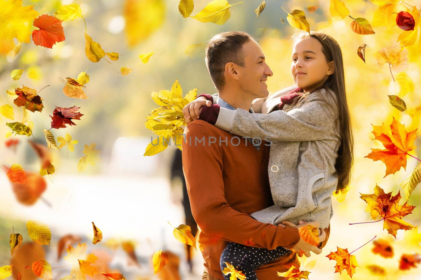Happy family father and child daughter on a walk in the autumn leaf fall in park. High quality photo