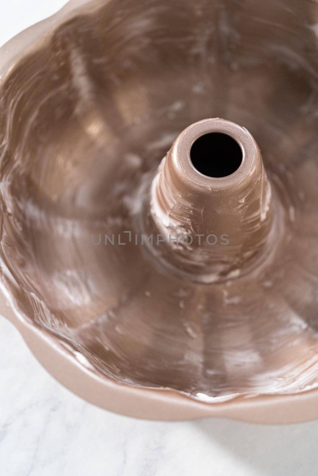 Greasing metal bundt cake pan to red velvet bundt cake with cream cheese glaze.