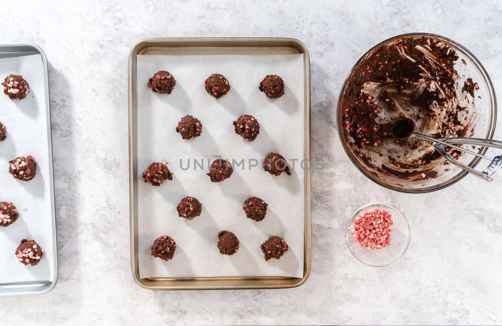 Flat lay. Scooping chocolate cookie dough with dough scoop to bake chocolate cookies with peppermint chips.