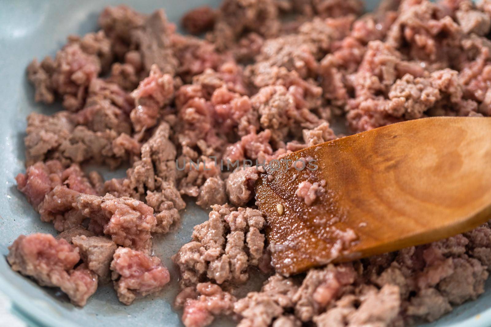 Browning ground turkey on a nonstick frying pan to bake turkey empanadas.