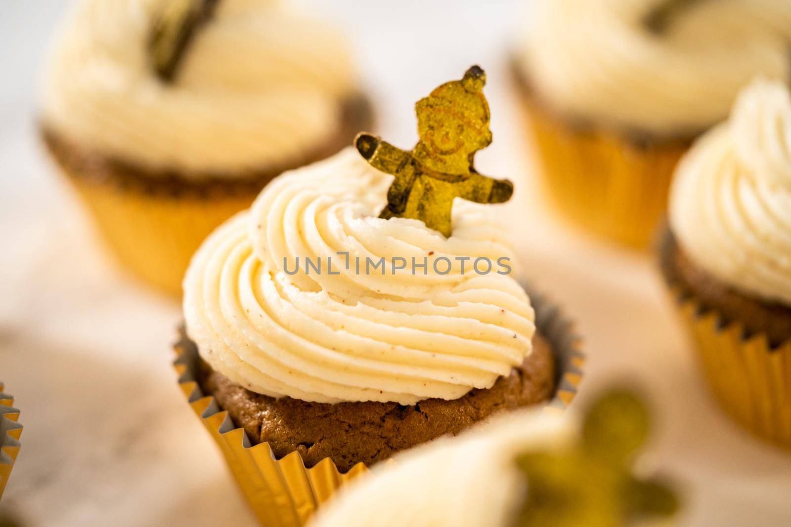 Freshly baked gingerbread cupcakes with eggnog buttercream frosting and topped with a gingerbread man.