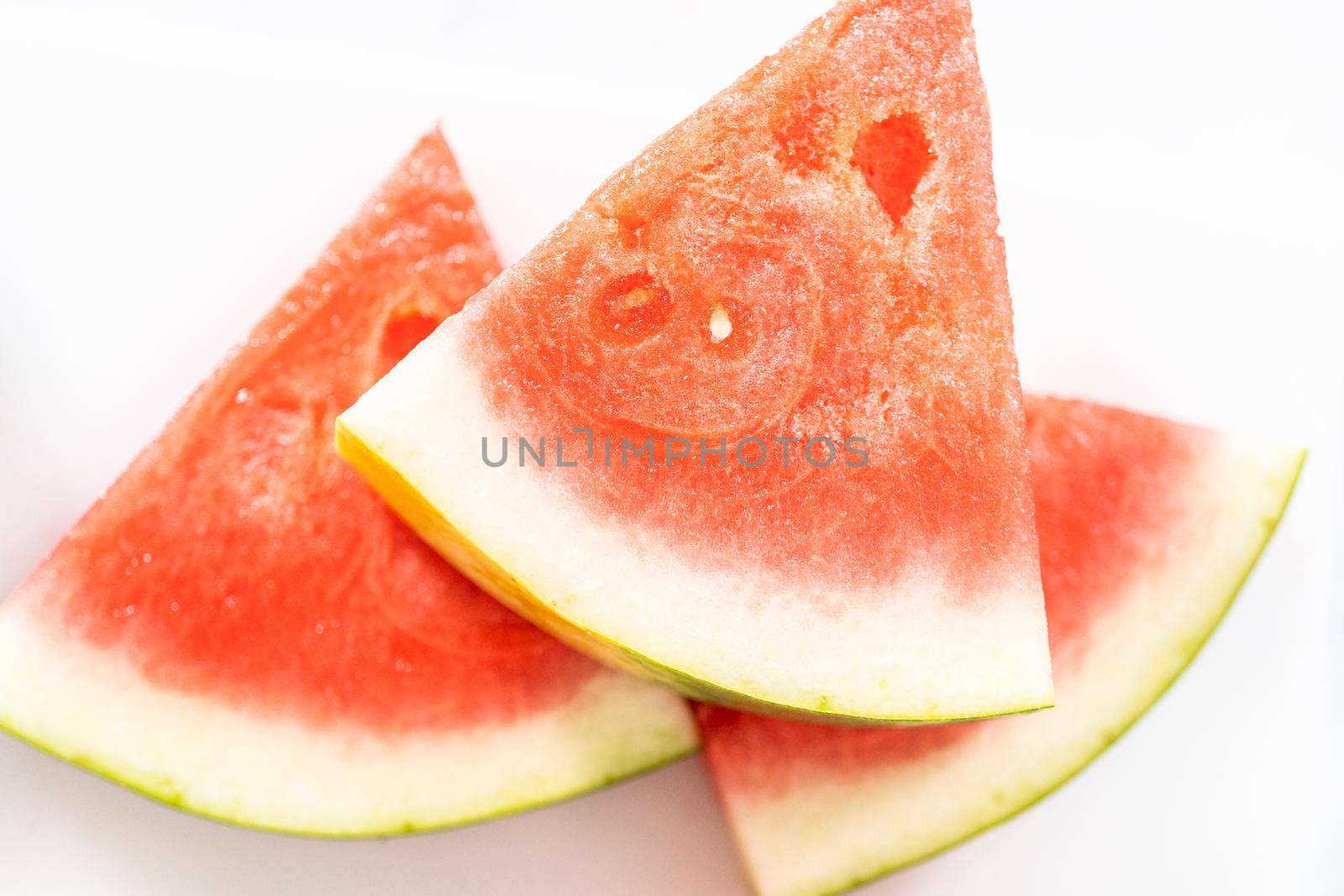 Slicing riped red watermelon to prepare chili lime watermelon pops.