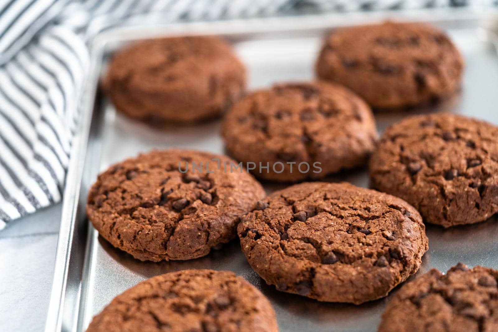 Freshly baked double chocolate chip cookies on a baking sheet.