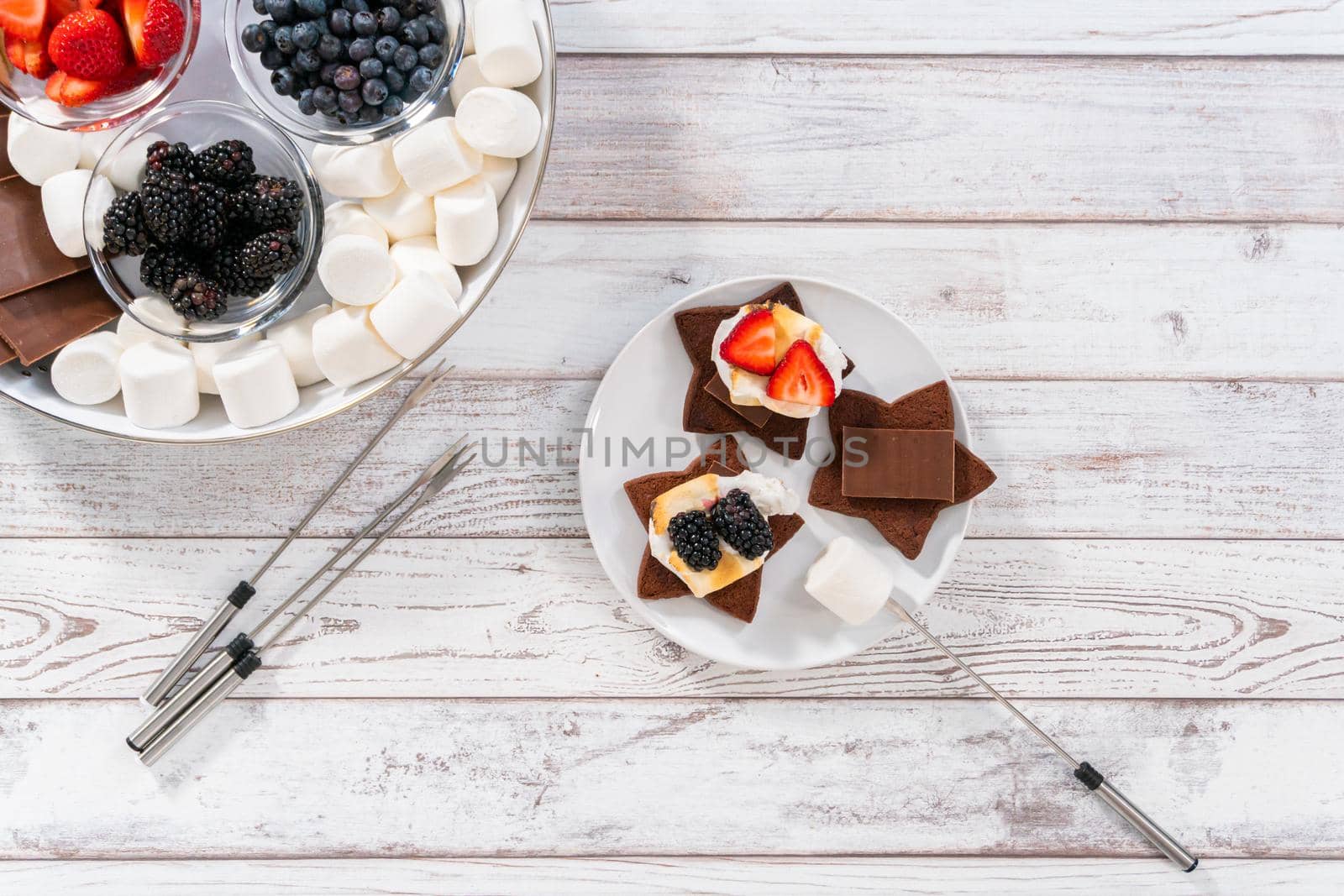 Making s'mores on a homemade star-shaped chocolate graham cracker with toasted marshmallow and fruits.