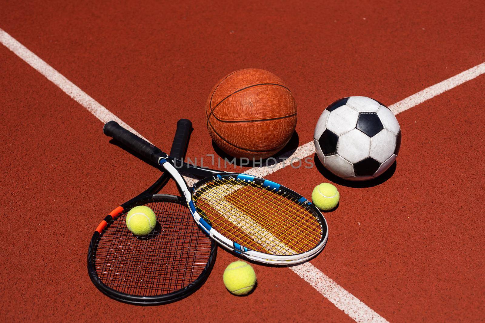 A group of sports equipment on black background including tennis, basketball, and soccer and boxing equipment on a background with copy space by Andelov13