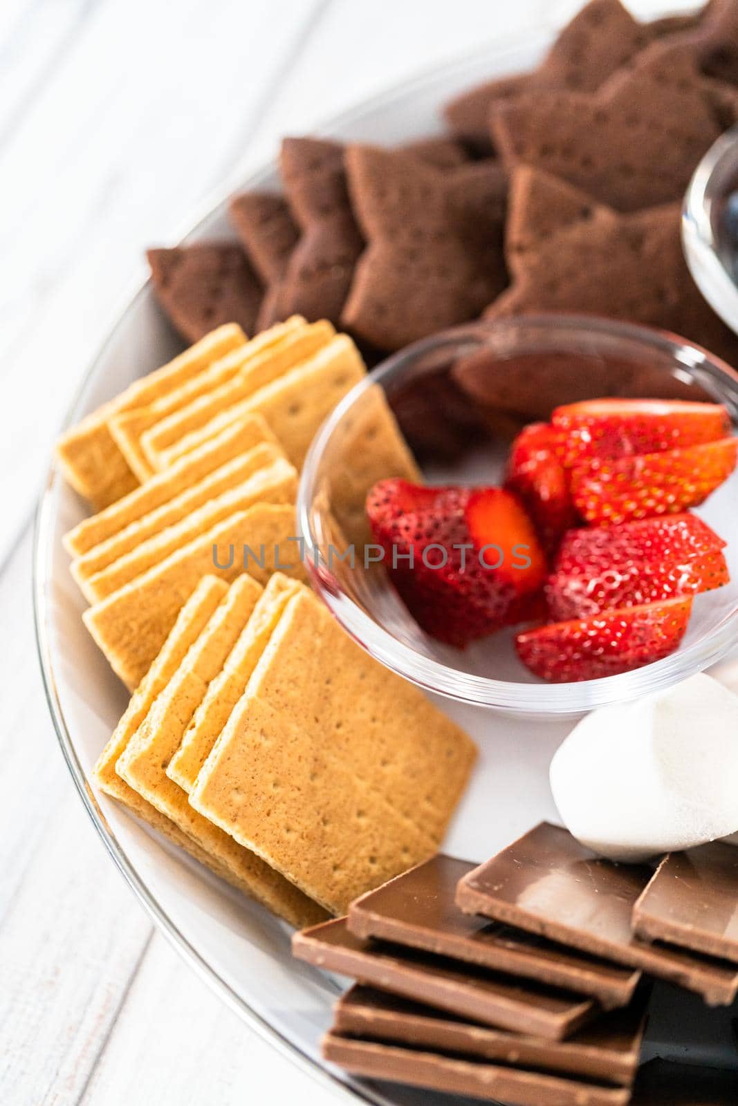 Arranging fruit s'mores charcuterie board on a white tray.